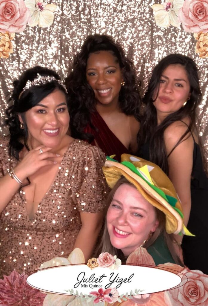 Group of friends posing at Juliet Yizel's Quinceañera celebration in Minneapolis, with a sparkly backdrop and floral decorations