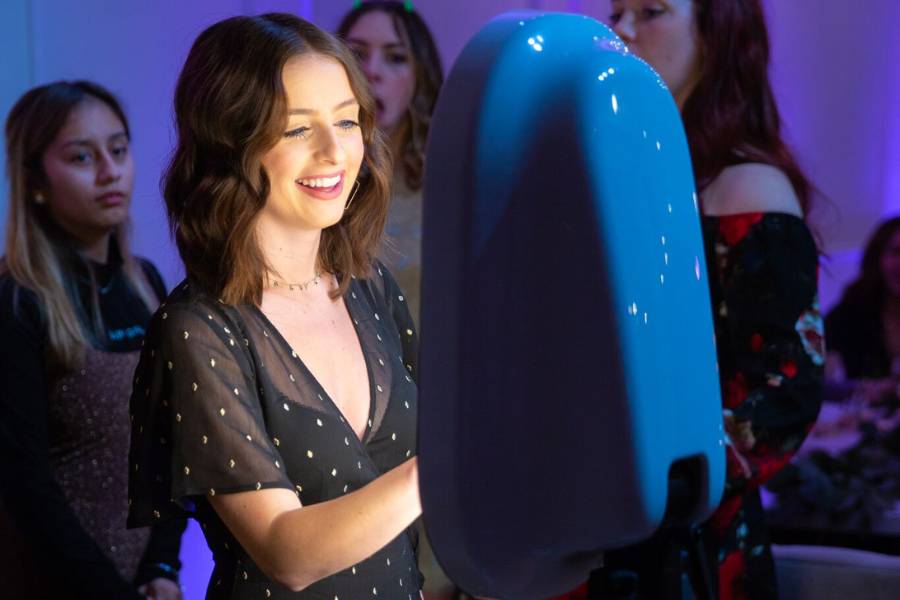 A young woman enjoying the photo booth at a Minneapolis event, smiling and posing for the camera